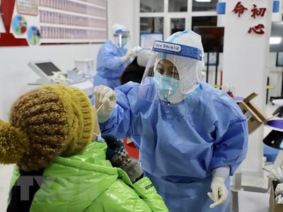 Nhân viên y tế lấy mẫu dịch xét nghiệm COVID-19 cho người dân tại thành phố Tuy Phân Hà, tỉnh Hắc Long Giang, Trung Quốc. (Ảnh: THX/TTXVN)