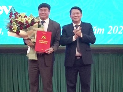 Ông Lò Minh Hùng, Phó Bí thư Thường trực tỉnh ủy Sơn La trao Quyết định và tặng hoa chúc mừng ông Vũ Đức Thuận.