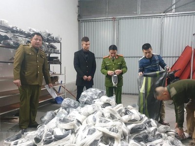 Lực lượng chức năng phát hiện thu giữ các sản phẩm quần áo, giầy dép lậu tại Hải Dương. (Ảnh: TTXVN phát).