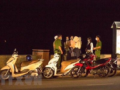 Lực lượng chức năng của thành phố Vũng Tàu, tỉnh Bà Rịa-Vũng Tàu xử lý các trường hợp người dân không đeo khẩu trang nơi công cộng đêm 9/2. (Ảnh: Kha San/TTXVN).