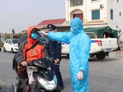 Đo thân nhiệt người dân ở chốt kiểm soát dịch bệnh tại Bắc Ninh. (Ảnh: Thái Hùng/TTXVN).