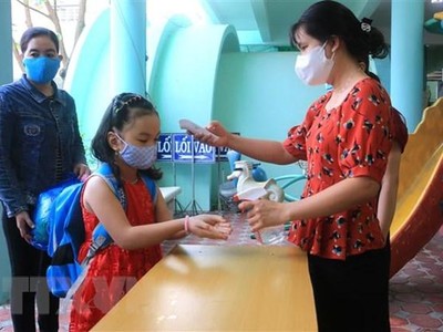 Đo thân nhiệt, rửa tay cho trẻ trước khi vào lớp. (Ảnh minh họa: Lê Thúy Hằng/TTXVN).