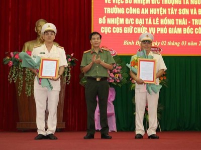 Giám đốc Công an tỉnh Bình Định trao quyết định của Bộ trưởng Bộ Công an cho Thượng tá Ngô Cự Vinh (thứ nhất bên trái sang) và Đại tá Lê Hồng Thái, Trưởng Phòng, Cục C05, Bộ Công an.