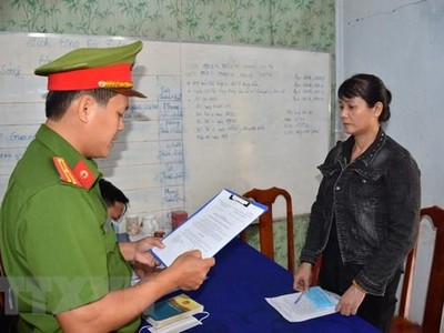 Cơ quan Cảnh sát điều tra Công an tỉnh tống đạt quyết định khởi tố bị can Nguyễn Thị Thanh Thúy. (Ảnh Công Trí/TTXVN).