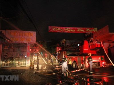 Lực lượng phòng cháy chữa cháy đang tích cực phun nước dập lửa, khống chế đám cháy. (Ảnh: An Đăng/TTXVN).
