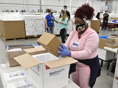 Một nhân viên đang đóng thùng vaccine ngừa Covid-19 của Johnson & Johnson vao các hộp bảo quản lạnh để chuẩn bị vận chuyển, ngày 1/3/2021. Ảnh: AP.