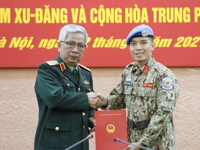 Thượng tướng Nguyễn Chí Vịnh, Thứ trưởng Bộ Quốc phòng trao Quyết định của Chủ tịch nước cho Trung tá Trần Đức Hưởng đi thực hiện nhiệm vụ tại Trụ sở Liên hợp quốc (tại New York, Hoa Kỳ). (Ảnh: Dương Giang/TTXVN).