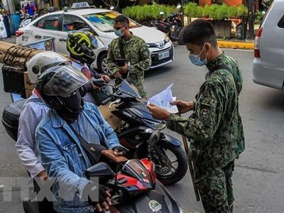 Cảnh sát làm nhiệm vụ tại một chốt kiểm tra y tế nhằm ngăn chặn sự lây lan của COVID-19 ở Manila, Philippines. (Ảnh: THX/TTXVN).