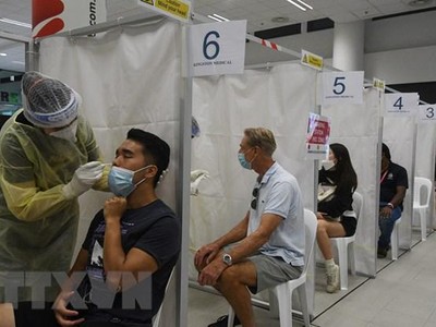 Nhân viên y tế lấy mẫu xét nghiệm COVID-19 cho người dân tại Singapore ngày 27/2/2021. (Ảnh: THX/TTXVN).