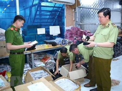 Lực lượng chức năng kiểm tra, niêm phong toàn bộ số hàng vi phạm. (Ảnh: Thùy Dung/TTXVN).