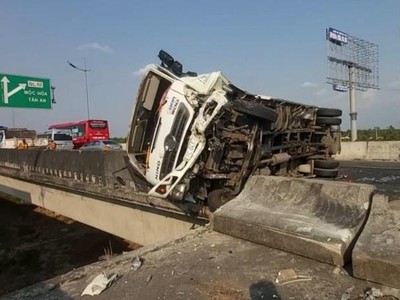 Sau cú tông mạnh của xe khách, xe tải bị lật trên tuyến cao tốc Trung Lương - TPHCM.