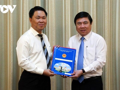 Chủ tịch UBND TPHCM Nguyễn Thành Phong (phải) trao quyết định cho ông Trần Hoàng Quân.