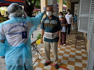 Kiểm tra thân nhiệt phòng lây nhiễm COVID-19 tại Phnom Penh, Campuchia. (Ảnh: AFP/TTXVN).