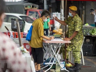 Kiểm tra thân nhiệt phòng dịch COVID-19 tại một khu chợ ở Kuala Lumpur, Malaysia, ngày 7/5/2021. (Ảnh: THX/TTXVN)