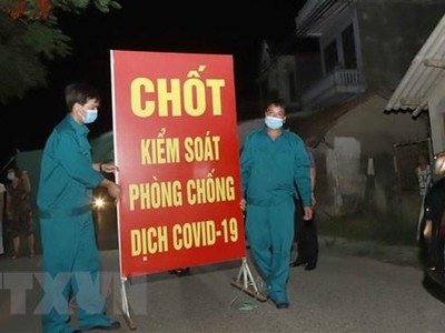 Lực lượng chức năng tiến hành tthu dọn vật dụng tại chốt cách ly tại thôn Tiền Phong, xã Tân Phong, huyện Bình Xuyên, Vĩnh Phúc. (Ảnh: Hoàng Hùng/TTXVN).