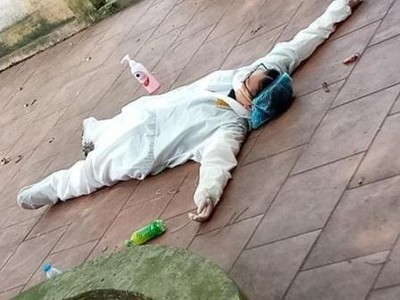 Nhân viên y tế dầm mình trong bộ đồ bảo hộ, làm việc nhiều giờ trong thời tiết nắng nóng gay gắt đã mệt lả nằm ngay xuống sân.