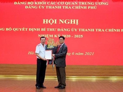 Bí thư Đảng ủy Khối các cơ quan Trung ương Huỳnh Tấn Việt trao quyết định và tặng hoa tân Bí thư Đảng ủy Thanh tra Chính phủ Đoàn Hồng Phong (trái). (Nguồn: thanhtra.com.vn).