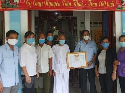 Cụ ông Nguyễn Văn Khai (thứ 5 từ trái sang), 100 tuổi, ngụ tại khóm Mỹ Thới, thị trấn Mỹ Thọ, huyện Cao Lãnh, Đồng Tháp, đã đóng góp tiền tiết kiệm cho Quỹ phòng, chống dịch bệnh COVID-19 và được Lãnh đạo Ủy ban MTTQ Việt Nam tỉnh Đồng Tháp đến trao Bằng khen Về hành động nhân ái ủng hộ phòng, chống dịch bệnh COVID-19. (Ảnh: TTXVN phát)