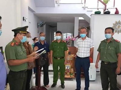 Thi hành quyết định khởi tố bị can, bắt tạm giam đối với Lee Kwan Young (áo trắng). (Ảnh: Công an cung cấp).