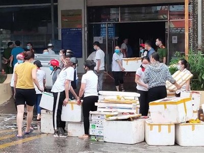 Nhân viên Siêu thị Ngọc Xuân dọn dẹp hàng hóa, đồ dùng sau vụ cháy. (Ảnh: Quốc Đạt/TTXVN).