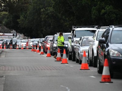 Người dân xếp hàng dài chờ được xét nghiệm Covid-19 tại khu vực Fairfield vào chiều tối 13/7. Ảnh: AAP.