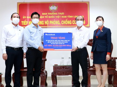 Đại diện Sacombank - ông Trần Minh Tâm, Giám đốc Chi nhánh Long An (bên trái), trao tặng 30 tỷ đồng cho Ủy ban Mặt trận Tổ quốc VN tại Long An để hỗ trợ người dân khó khăn do Covid-19.