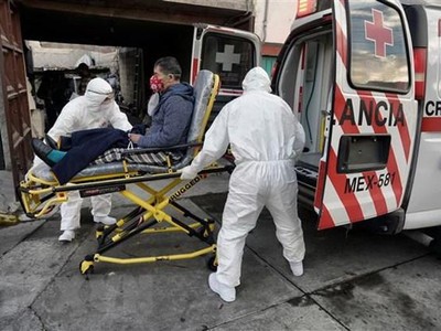 Nhân viên y tế chuyển bệnh nhân nhiễm COVID-19 lên xe cứu thương tại Toluca, Mexico. (Ảnh: AFP/TTXVN).