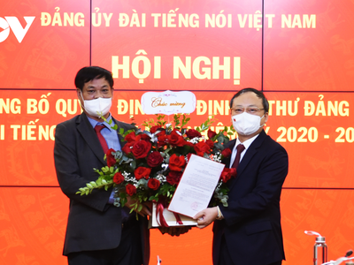 Ông Huỳnh Tấn Việt, Bí thư Đảng ủy Khối các cơ quan Trung ương trao quyết định và tặng hoa chúc mừng ông Đỗ Tiến Sỹ.