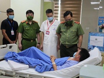 Trung tướng Nguyễn Hải Trung, Giám đốc Công an thành phố Hà Nội động viên Đại úy Ngô Hải Phú, cán bộ Công an phường Khương Trung, quận Thanh Xuân, Hà Nội. (Ảnh: TTXVN phát).