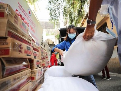 Hỗ trợ gạo và thực phẩm cho người dân gặp khó khăn do dịch COVID-19. (Ảnh: TTXVN).