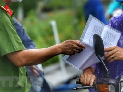 Kiểm tra giấy đi đường của người dân. (Nguồn: TTXVN).