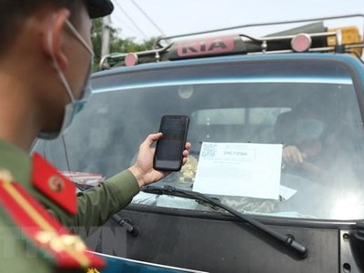 Lực lượng chức năng tại chốt kiểm soát đầu cầu Trung Hà (huyện Ba Vì) quét mã QR Code kiểm tra thông tin phương tiện theo đăng ký khi qua chốt. (Ảnh: Minh Quyết/TTXVN).