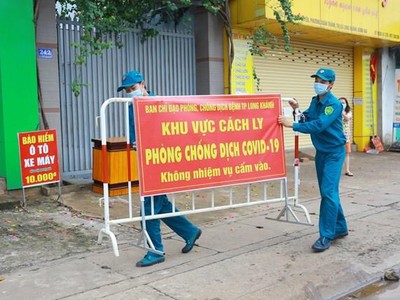 Lực lượng chức năng thực hiện dỡ bỏ phong tỏa cho 20 hộ dân tại khu phố 2, phường Xuân Thanh. (Ảnh: Lê Xuân/TTXVN).