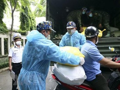 Phân phối gạo cho người dân gặp khó khăn ở địa bàn quận 4. (Nguồn: TTXVN).