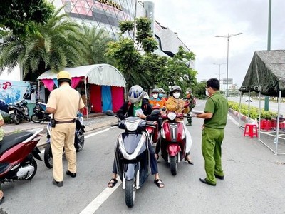 Lực lượng Công an tại chốt kiểm trên đường Phạm Văn Đồng, phường Hiệp Bình Chánh, Thủ Đức, kiểm tra giấy tờ của người lưu thông. (Ảnh: Thành Chung/TTXVN).