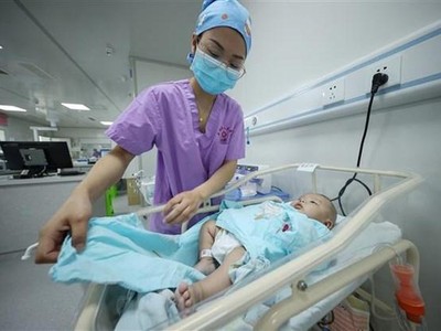 Nhân viên y tế chăm sóc trẻ mới sinh tại bệnh viện ở tỉnh Quý Châu (Trung Quốc), ngày 11/5/2021. (Ảnh: AFP/TTXVN).