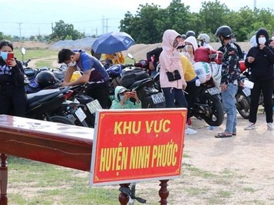 Người dân từ Đồng Nai về được tập trung theo khu vực để kiểm tra dịch bệnh trước khi đưa đi cách ly tập trung. (Ảnh: Công Thử/TTXVN).