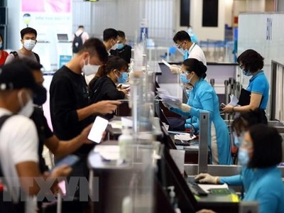 Hành khách phải tiêm đủ 2 mũi vaccine phòng COVID-19 sau 14 ngày hoặc có giấy xác nhận là F0 khỏi bệnh dưới 6 tháng và xuất trình kết quả xét nghiệm âm tính trong vòng 72 giờ trước khi lên máy bay. (Ảnh: Huy Hùng/TTXVN).