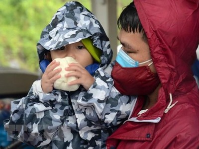 Người về quê tranh thủ nghỉ chân, ăn đồ ăn miễn phí trước khi tiếp tục lên đường. (Ảnh: Quốc Dũng/TTXVN).