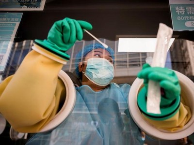 Nhân viên y tế làm xét nghiệm Covid-19 tại một trạm trên đường phố Bắc Kinh hôm 20/10 (Ảnh: Reuters).