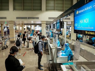 Hành khách Vietnam Airlines làm thủ tục ở quầy check-in sân bay Tân Sơn Nhất. (Ảnh: CTV/Vietnam+).