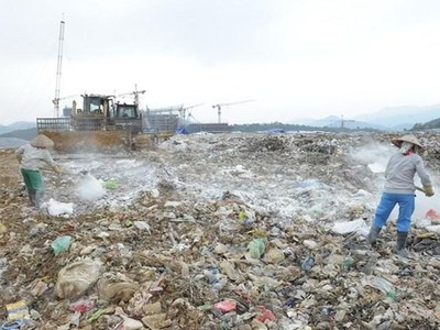 Công ty TNHH MTV Môi trường Đô thị Hà Nội rắc chế phẩm khử mùi tại bãi rác Nam Sơn. (Ảnh: Mạnh Khánh/TTXVN).