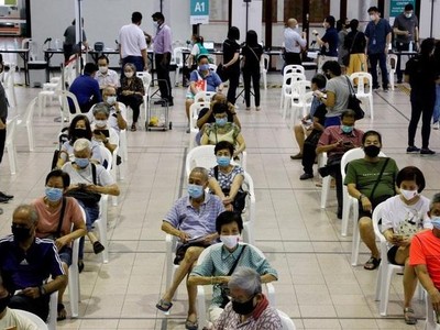 Người dân chờ đợi tiêm vắc xin Covid-19 ở Singapore (Ảnh: Reuters).