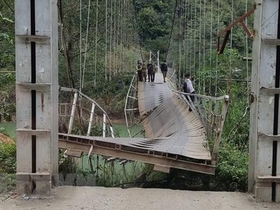 Cầu treo Nam Quang bị đứt gãy khiến xe tải chở hàng rơi xuống sông. (Ảnh: TTXVN phát).