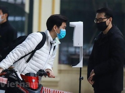 Học sinh được đo thân nhiệt và khử khuẩn tại khu vực cổng trường trước khi lên lớp. (Ảnh: Hoài Nam/Vietnam+).