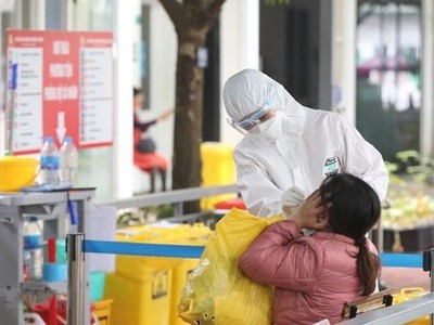 Nhân viên y tế bệnh viện Thanh Nhàn lấy mẫu xét nghiệm COVID-19 cho người đến khám có triệu chứng. (Ảnh: Minh Quyết/TTXVN).