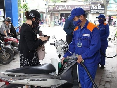 Nhân viên Petrolimex bán xăng cho khách hàng. (Ảnh: Đức Duy/Vietnam+).