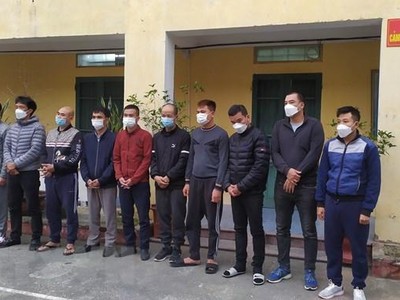 Đối tượng cầm đầu Nguyễn Xuân Tiến (đứng thứ 3, từ phải sang) cùng 9 đối tượng khác tại cơ quan công an. (Ảnh: TTXVN phát).