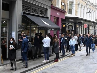 Người dân xếp hàng mua đồ bên ngoài một cửa hàng ở London (Anh), ngày 29/4/2021. (Ảnh: AFP/TTXVN).