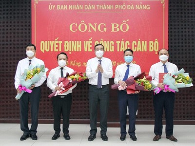 Ông Lê Trung Chinh (giữa), Chủ tịch UBND thành phố Đà Nẵng trao Quyết định và tặng hoa chúc mừng các cán bộ được điều động, bổ nhiệm vị trí công tác mới.
